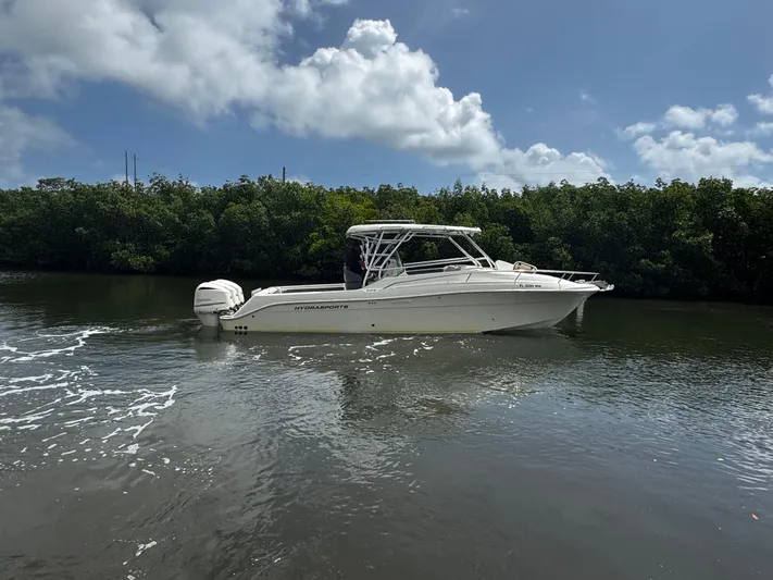  Yacht Photos Pics 2005 Hydra-Sports 3300 VX boat cruising on a calm river under a partly cloudy sky.