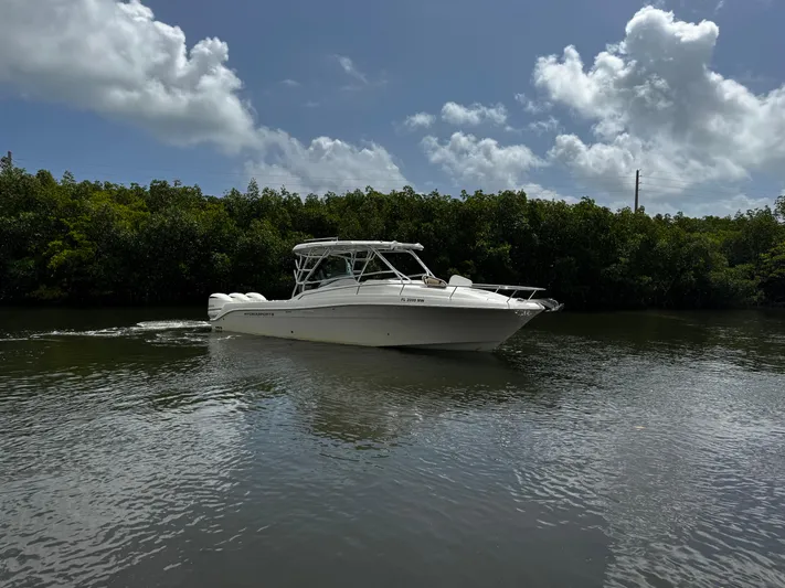  Yacht Photos Pics 2005 Hydra-Sports 3300 VX boat cruising on a calm river under a cloudy sky.