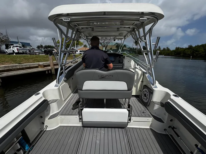  Yacht Photos Pics 2005 Hydra-Sports 3300 VX boat interior with captain at helm, docked by a scenic waterway.