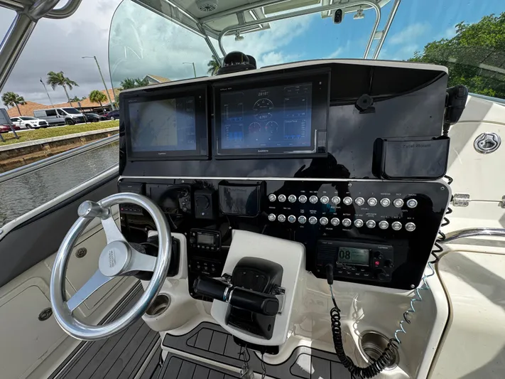  Yacht Photos Pics Control panel of a 2005 Hydra-Sports 3300 VX boat with steering wheel and navigation screens.