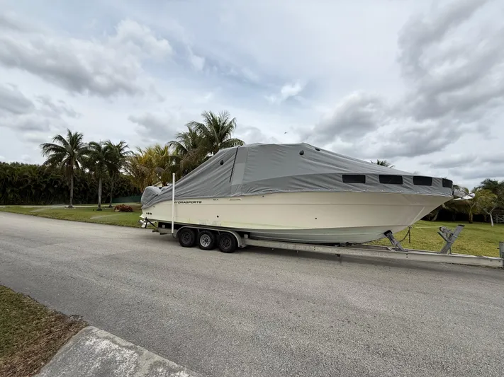  Yacht Photos Pics 2005 Hydra-Sports 3300 VX boat covered on trailer, parked near palm trees.