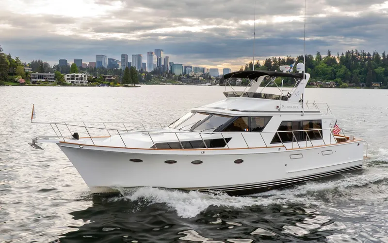  Yacht Photos Pics 1989 Ocean Alexander 50 Sedan yacht cruising on a scenic lake with city skyline backdrop.