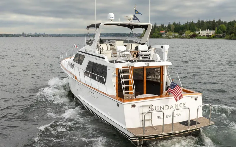  Yacht Photos Pics 1989 Ocean Alexander 50 Sedan yacht cruising on a lake, displaying an American flag.