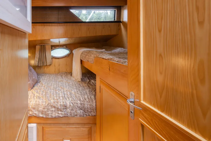  Yacht Photos Pics Cozy cabin interior of 1989 Ocean Alexander 50 Sedan with wooden finish and bunk beds.