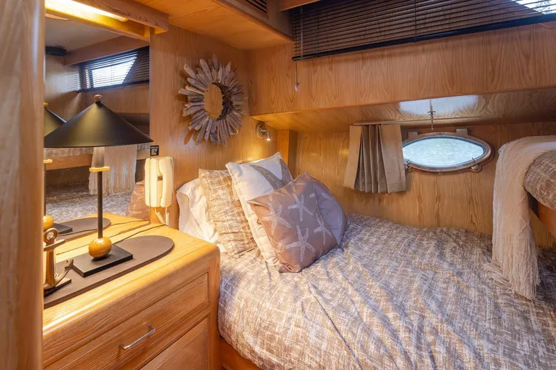  Yacht Photos Pics Cozy bedroom interior of 1989 Ocean Alexander 50 Sedan yacht with wooden decor and soft lighting.