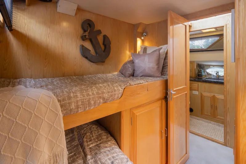  Yacht Photos Pics Cozy cabin interior of 1989 Ocean Alexander 50 Sedan with wooden bunk beds and nautical decor.