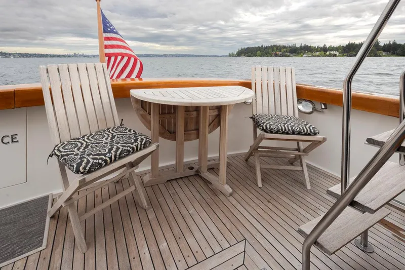  Yacht Photos Pics 1989 Ocean Alexander 50 Sedan yacht deck with chairs, table, and American flag.