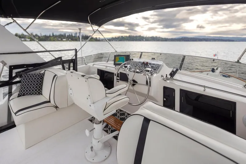  Yacht Photos Pics 1989 Ocean Alexander 50 Sedan yacht interior with steering wheel and seating, on a calm lake.