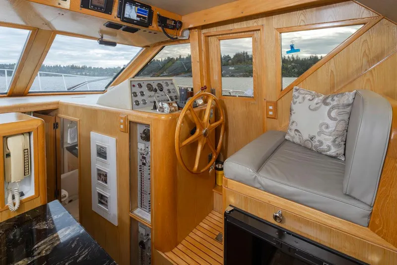  Yacht Photos Pics 1989 Ocean Alexander 50 Sedan interior with wooden helm, steering wheel, and cushioned seating.