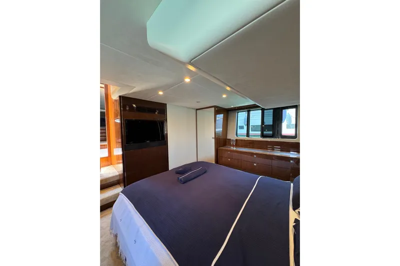  Yacht Photos Pics Luxurious bedroom interior of 2012 Princess 60 yacht with elegant wood finishes.