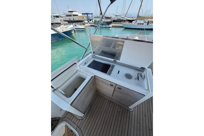  Yacht Photos Pics Outdoor kitchenette on 2012 Princess 60 yacht, featuring sink and storage, docked in marina.