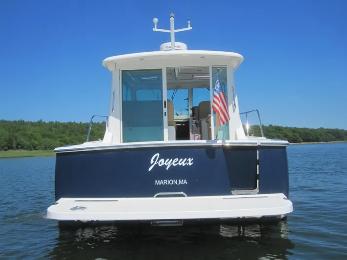  Yacht Photos Pics 2014 Back Cove 34 Hard Top boat on water, rear view, American flag displayed.