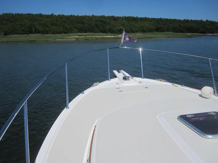  Yacht Photos Pics 2014 Back Cove 34 Hard Top boat on calm water with forested shoreline.