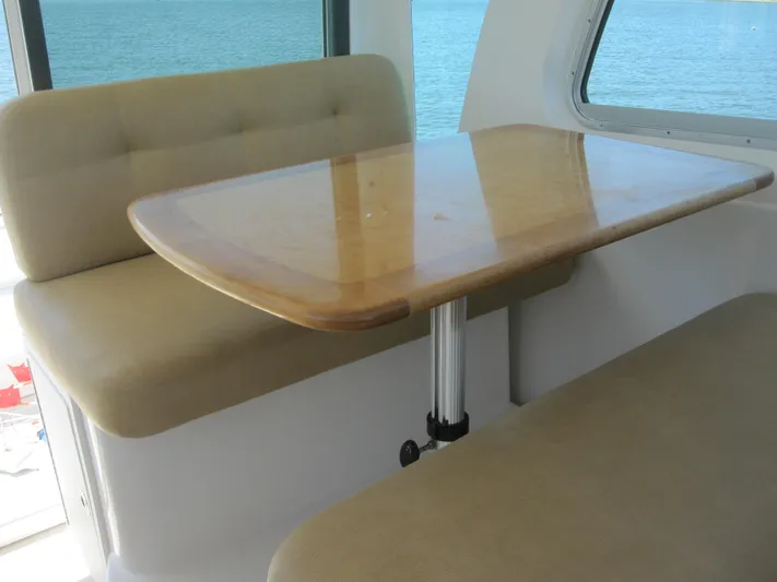  Yacht Photos Pics Interior of 2014 Back Cove 34, featuring a wooden table and cushioned seating.