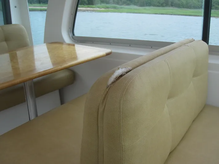  Yacht Photos Pics Interior of 2014 Back Cove 34 boat with beige seating and wooden table.