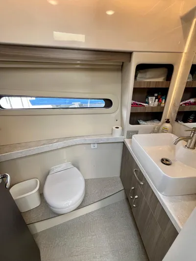  Yacht Photos Pics 2022 Regal 38 XO yacht bathroom with modern sink, toilet, and storage shelves.