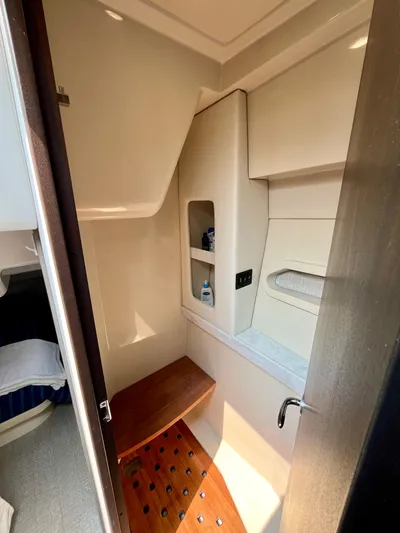  Yacht Photos Pics 2022 Regal 38 XO yacht bathroom with wooden bench and storage shelves.