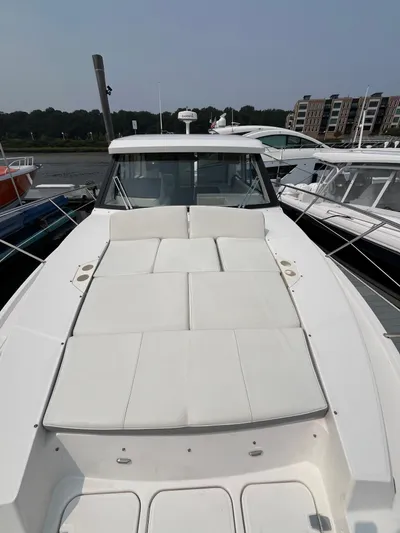  Yacht Photos Pics 2022 Regal 38 XO yacht with spacious sunbathing deck, docked at marina.