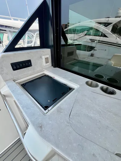  Yacht Photos Pics 2022 Regal 38 XO yacht kitchenette with sleek countertop and built-in appliances.