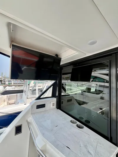  Yacht Photos Pics 2022 Regal 38 XO yacht interior with TV and sleek countertop.