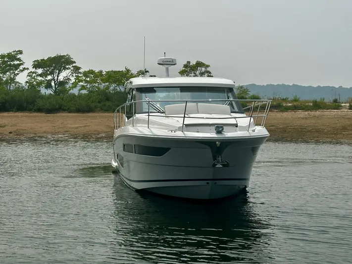  Yacht Photos Pics 2022 Regal 38 XO yacht on calm water near a shoreline.