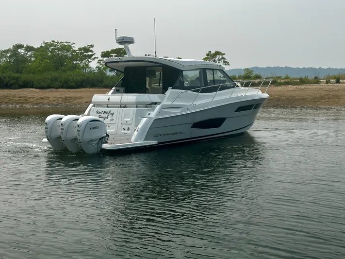  Yacht Photos Pics 2022 Regal 38 XO boat with triple Yamaha engines on calm water.