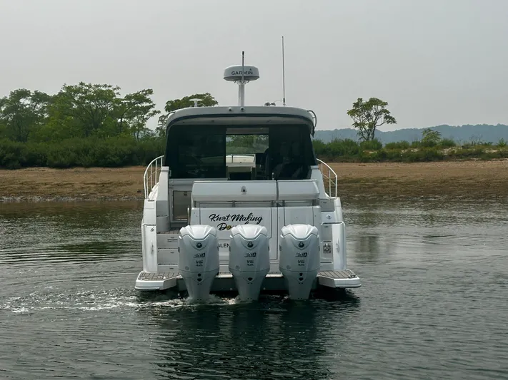  Yacht Photos Pics 2022 Regal 38 XO boat with triple outboard engines on calm water.