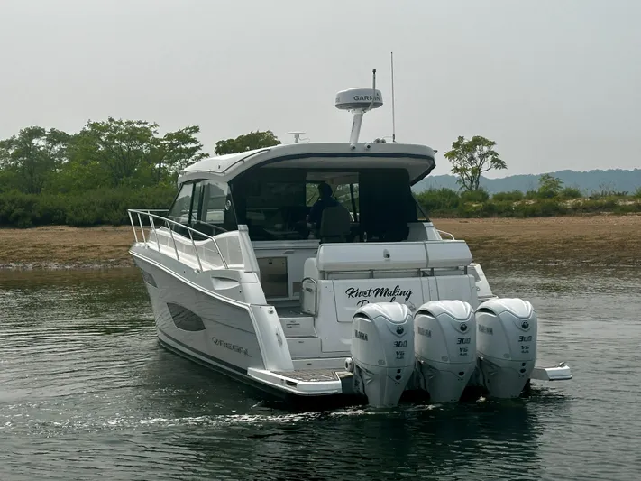  Yacht Photos Pics 2022 Regal 38 XO boat with triple Yamaha engines on calm water.