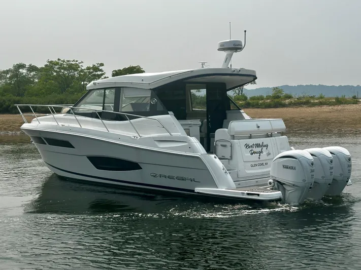  Yacht Photos Pics 2022 Regal 38 XO boat cruising on water with triple Yamaha engines.