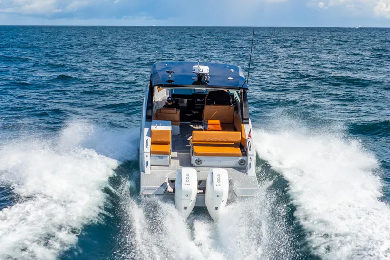 South Beach Edition -- Like New Trade In Yacht Photos Pics 2024 Cruisers Yachts 34 GLS OB cruising on open water, rear view.