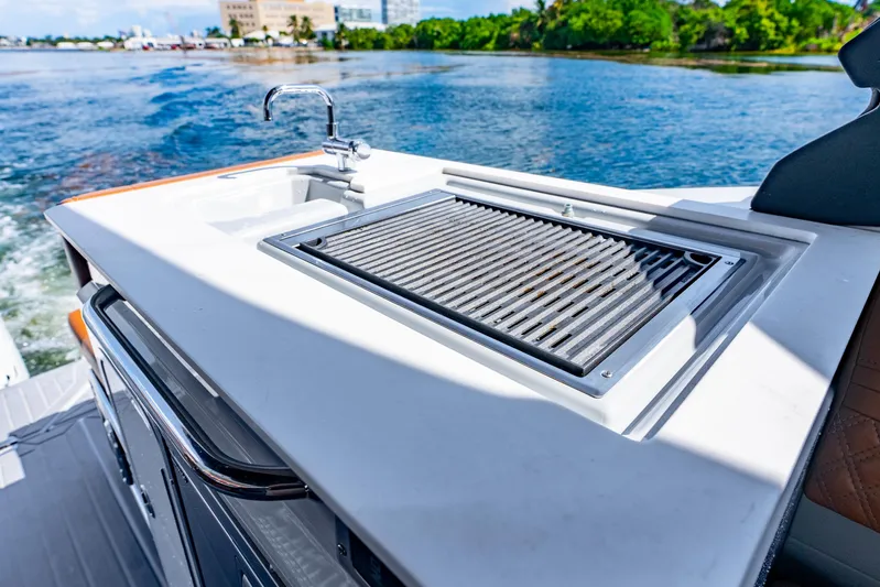 South Beach Edition -- Like New Trade In Yacht Photos Pics Outdoor kitchen on 2024 Cruisers Yachts 34 GLS OB, featuring a grill and sink by the water.