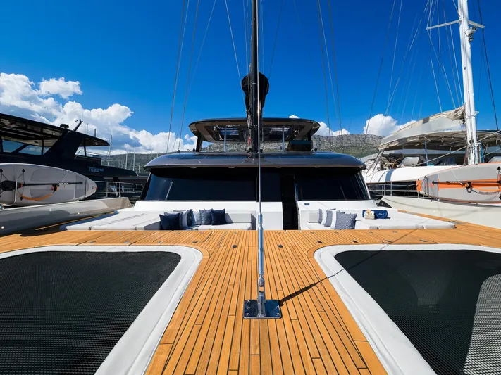 N+1 Yacht Photos Pics 2024 Sunreef 70 Eco yacht with spacious deck and luxurious seating under clear blue sky.