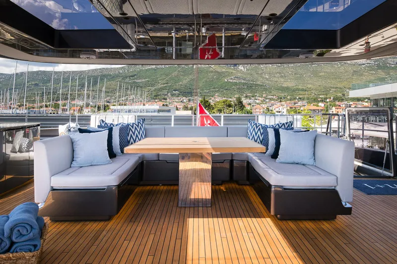 N+1 Yacht Photos Pics Luxurious deck seating on 2024 Sunreef 70 Eco yacht with scenic marina view.