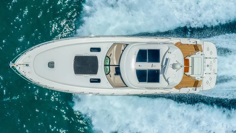 Three Sons Yacht Photos Pics Aerial view of 2008 Sea Ray Sundancer yacht cruising on blue ocean waters.