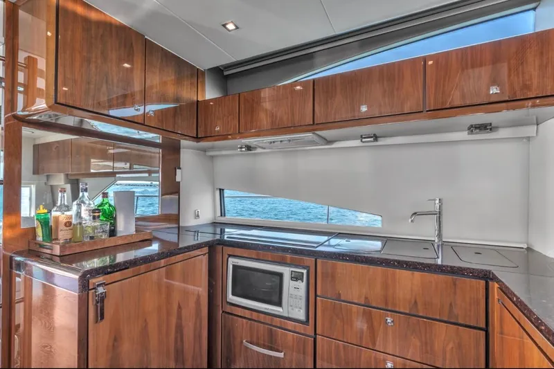  Yacht Photos Pics Luxurious kitchen interior of 2013 Fairline Squadron 66 yacht with wood cabinetry and ocean view.