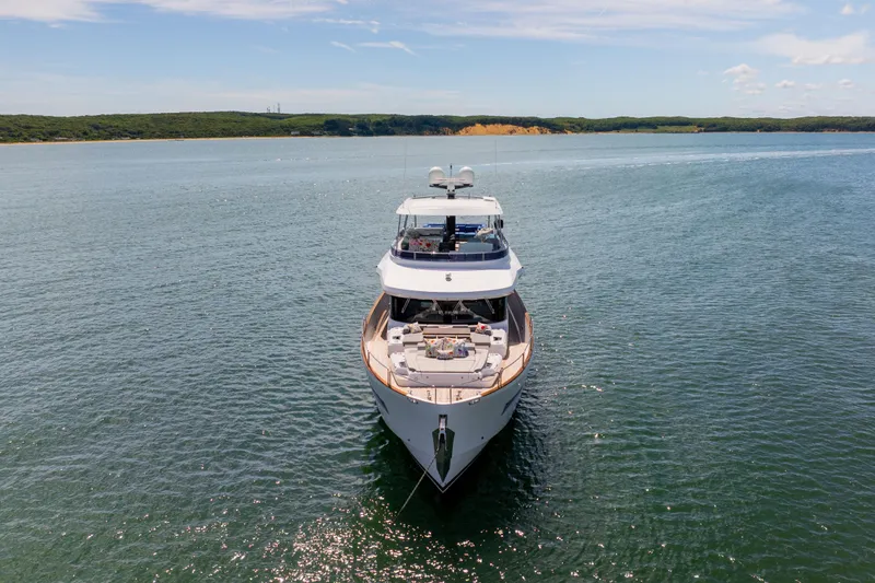 Amor Fati Yacht Photos Pics Luxurious 2019 Sirena 64 yacht on serene waters under a clear sky.