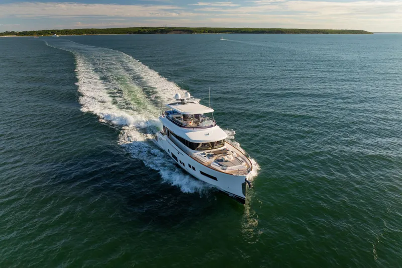 Amor Fati Yacht Photos Pics Luxurious 2019 Sirena 64 yacht cruising on open water under a clear sky.