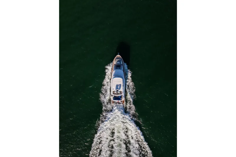 Amor Fati Yacht Photos Pics Aerial view of 2019 Sirena 64 yacht cruising on open water.