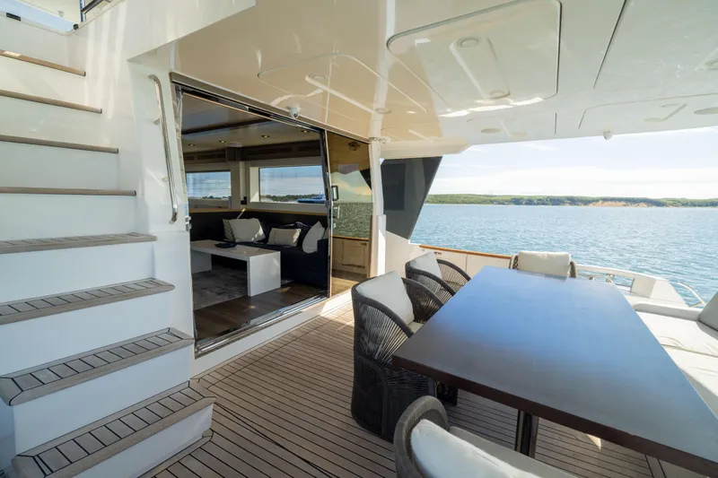 Amor Fati Yacht Photos Pics Luxurious 2019 Sirena 64 yacht deck with seating, table, and ocean view.