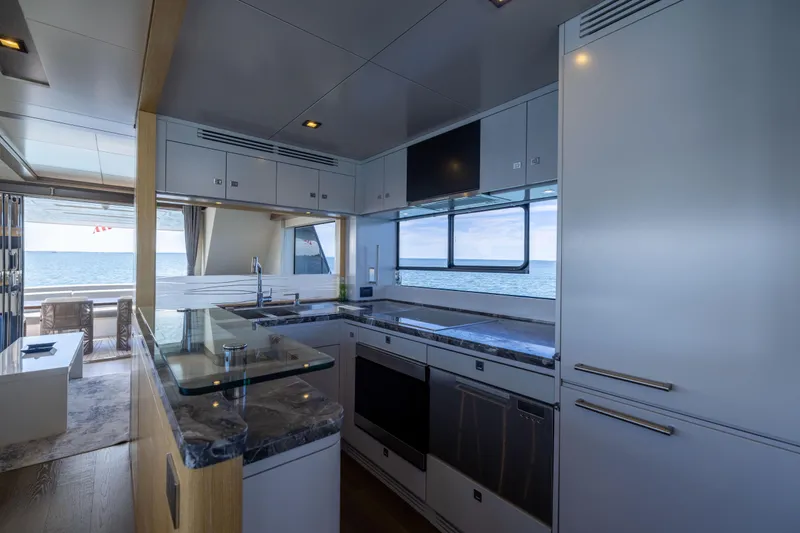 Amor Fati Yacht Photos Pics Luxurious kitchen interior of 2019 Sirena 64 yacht with ocean view.
