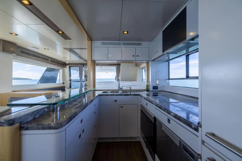 Amor Fati Yacht Photos Pics Luxurious kitchen interior of 2019 Sirena 64 yacht with modern appliances and ocean view.