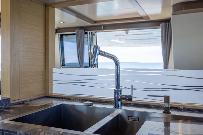 Amor Fati Yacht Photos Pics Modern kitchen sink on 2019 Sirena 64 yacht, featuring sleek design and ocean view.