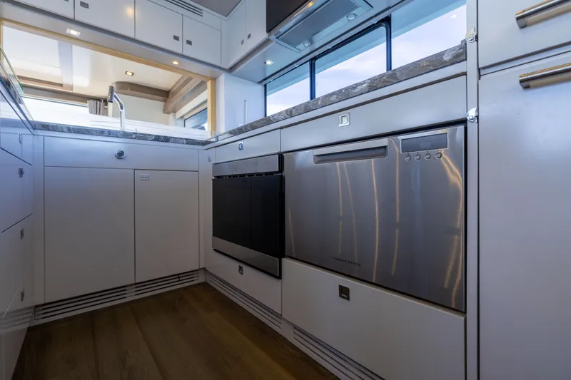 Amor Fati Yacht Photos Pics Modern kitchen interior on 2019 Sirena 64 yacht, featuring sleek cabinetry and stainless steel appliances.