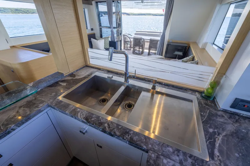 Amor Fati Yacht Photos Pics Luxurious kitchen interior on 2019 Sirena 64 yacht with dual sinks and ocean view.