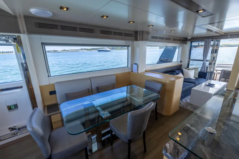 Amor Fati Yacht Photos Pics Luxurious interior of 2019 Sirena 64 yacht with elegant dining and lounge area.