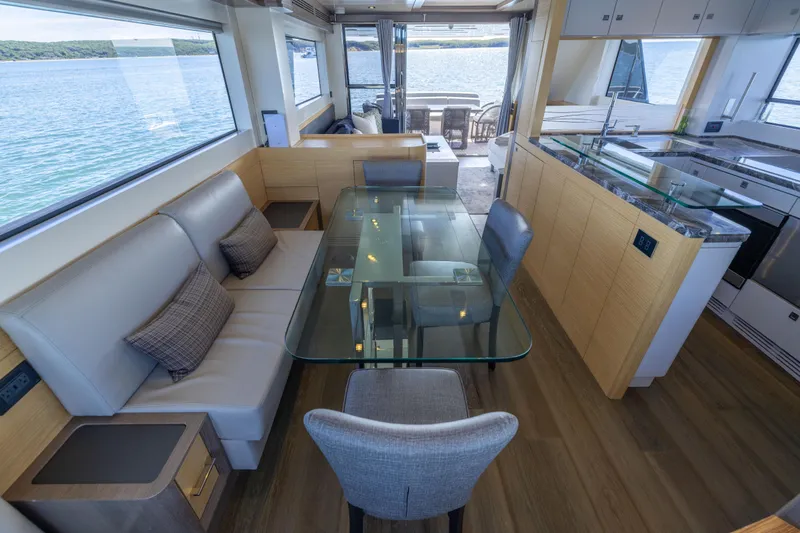 Amor Fati Yacht Photos Pics Luxurious interior of 2019 Sirena 64 yacht with modern dining area and scenic ocean view.