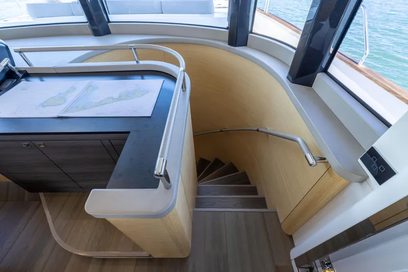 Amor Fati Yacht Photos Pics Interior of 2019 Sirena 64 yacht with navigation desk and curved staircase.