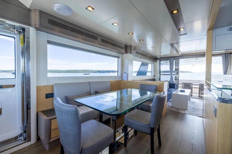 Amor Fati Yacht Photos Pics Luxurious interior of 2019 Sirena 64 yacht with modern dining area and scenic ocean views.