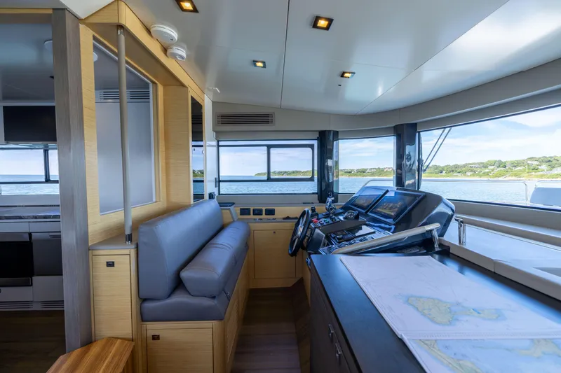 Amor Fati Yacht Photos Pics 2019 Sirena 64 yacht interior with modern helm, navigation screens, and panoramic windows.