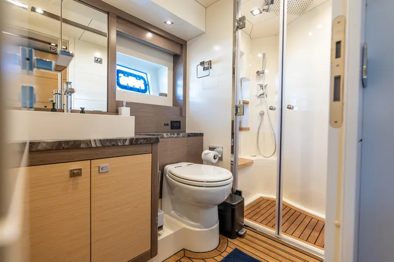 Amor Fati Yacht Photos Pics Luxurious bathroom in 2019 Sirena 64 yacht with modern fixtures and wooden accents.